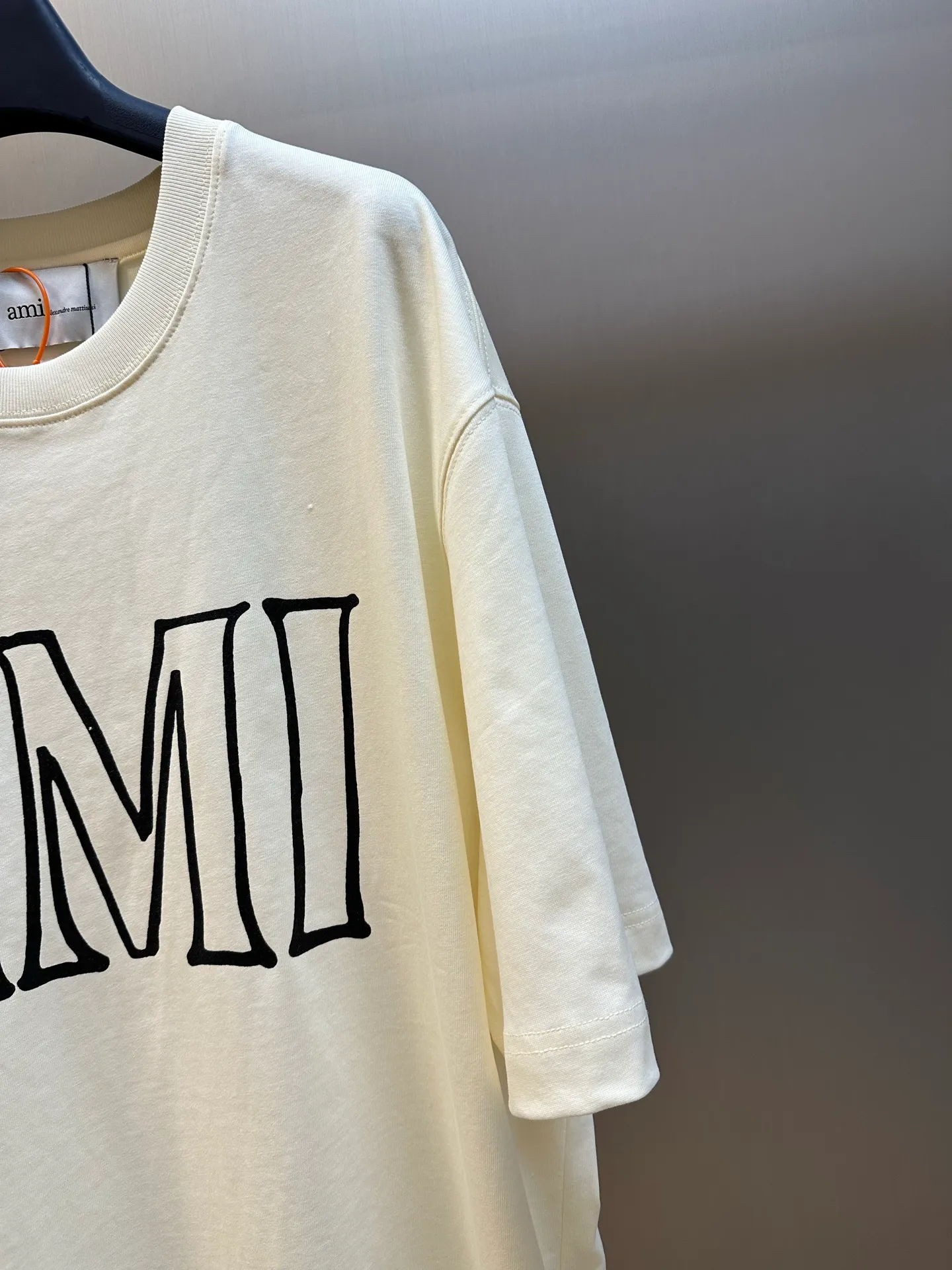 Ami Paris letter-printed box-shaped short-sleeves, custom-made cloud-like breathable cotton fabric, French minimalist all-purpose background color, AMI printing on the front is my signature, PARIS printing on the back is a romantic belonging, echoing from front to back. The iconic love logo is hidden on the sleeves and is a secret code on the streets of Paris. It uses detailed metaphors to interpret an effortless sense of luxury. With glue printing, glue liquid paint is used to print patterns on the fabric, and the fabric is baked to fix the printed pattern. size：s m l xl